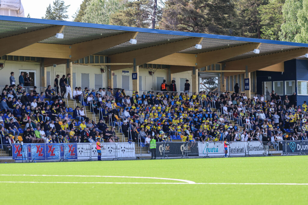 Oulunkylän stadionin puukatoksinen katsomo täynnä yleisöä ottelupäivänä